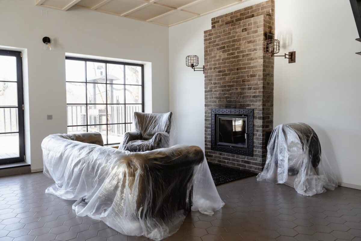 Plastic-wrapped furniture in a newly renovated modern living room.
